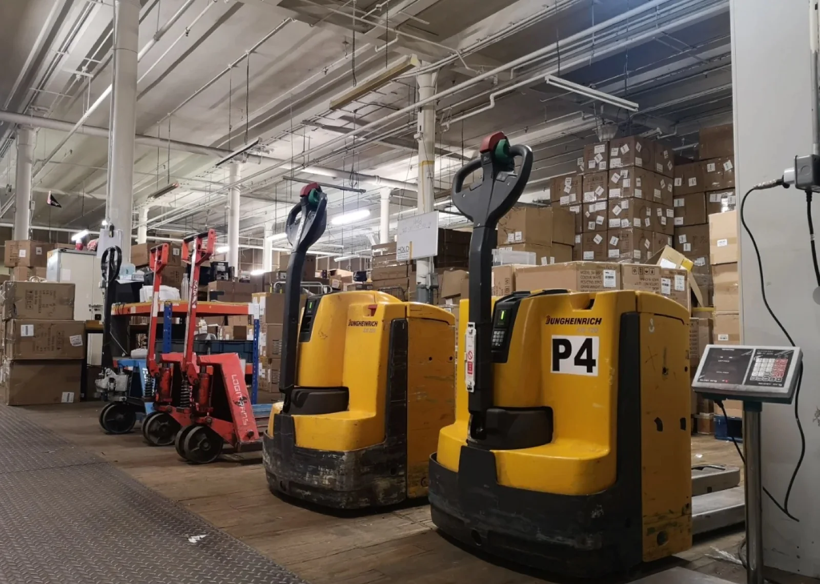 Warehouse handling equipment beside stacked cartons